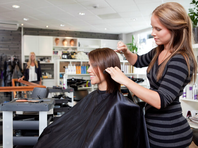 Hairdresser cutting hair in beauty salon