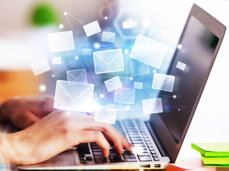 Woman at laptop, superimposed with envelop icons