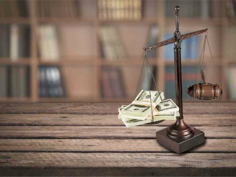 Balance with money and gavel sitting on desk