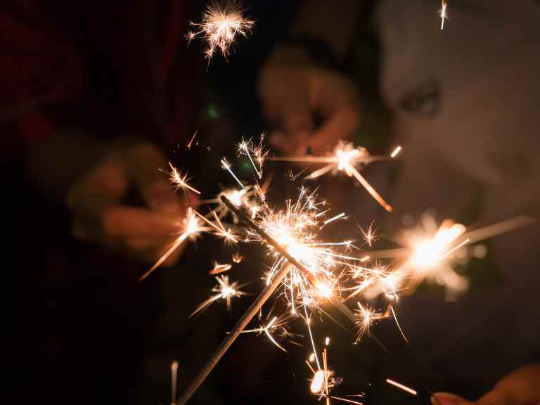 Hands holding lit sparklers